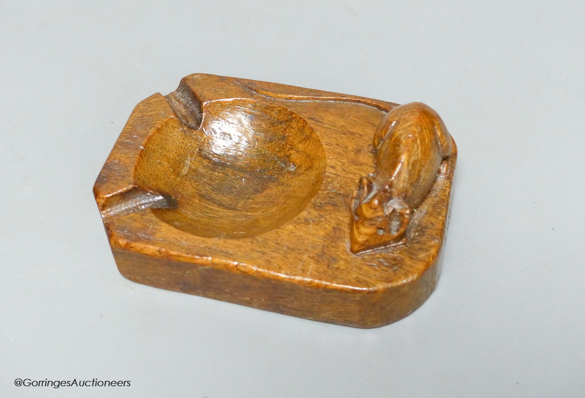 A Mouseman oak ashtray, width 10cm, slight loss to ear